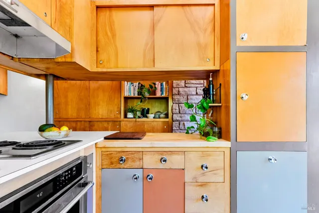a kitchen with stainless steel appliances a sink a counter top space and a view of living room