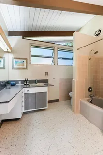 a bedroom with a bed next to a window