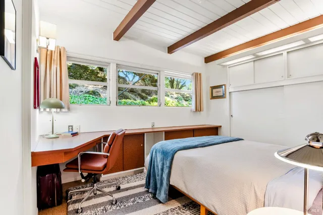 a bedroom with a bed and a desk