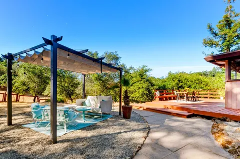 a view of a patio with table and chairs potted plants with wooden fence
