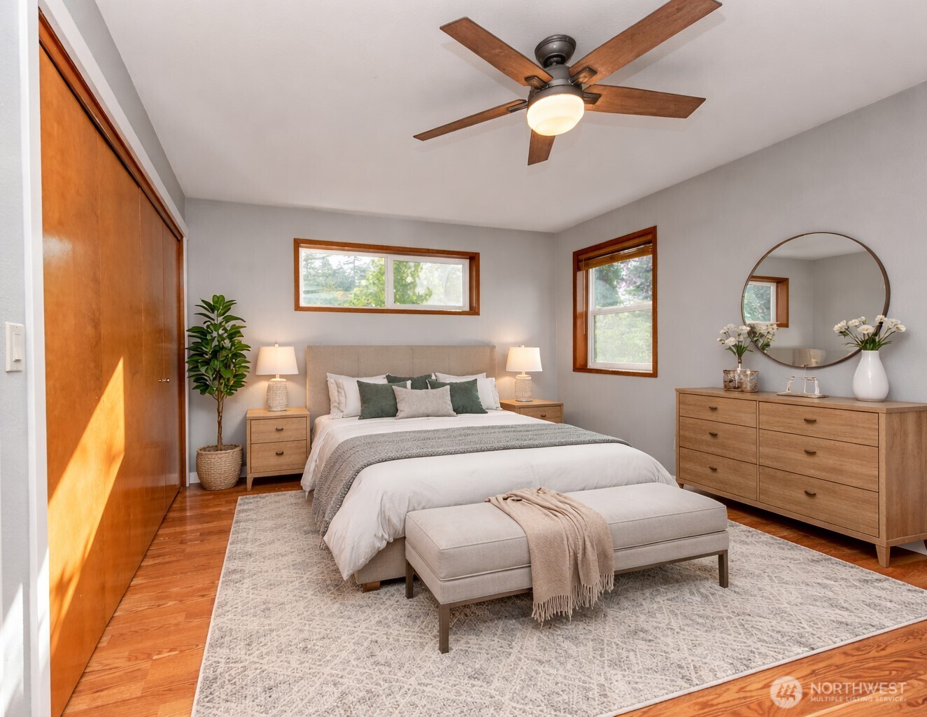 151 Nicole Place Sequim, WA 98382 - Photo 20 of 40 a spacious bedroom with a bed a dresser and potted plants with the wooden floor