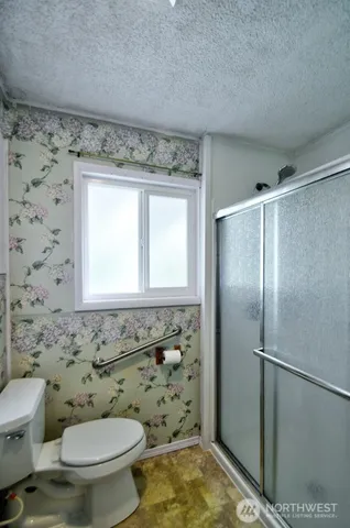 a bathroom with a granite countertop toilet a sink and a shower