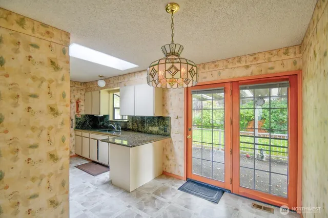 a kitchen with stainless steel appliances granite countertop a sink a stove top oven a granite counter tops and a view of living room