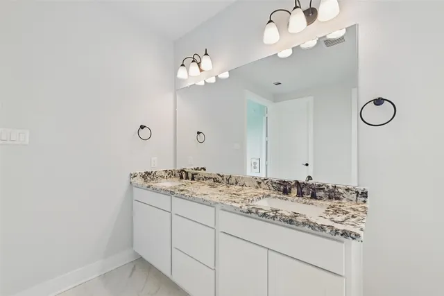 a bathroom with a sink vanity and a mirror