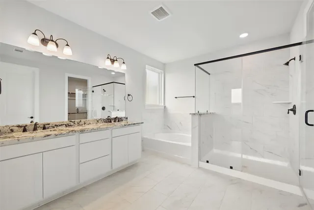 a spacious bathroom with a bathtub shower sink mirror and