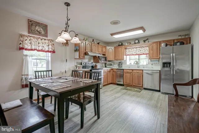 a kitchen with granite countertop stainless steel appliances a sink cabinets and a window