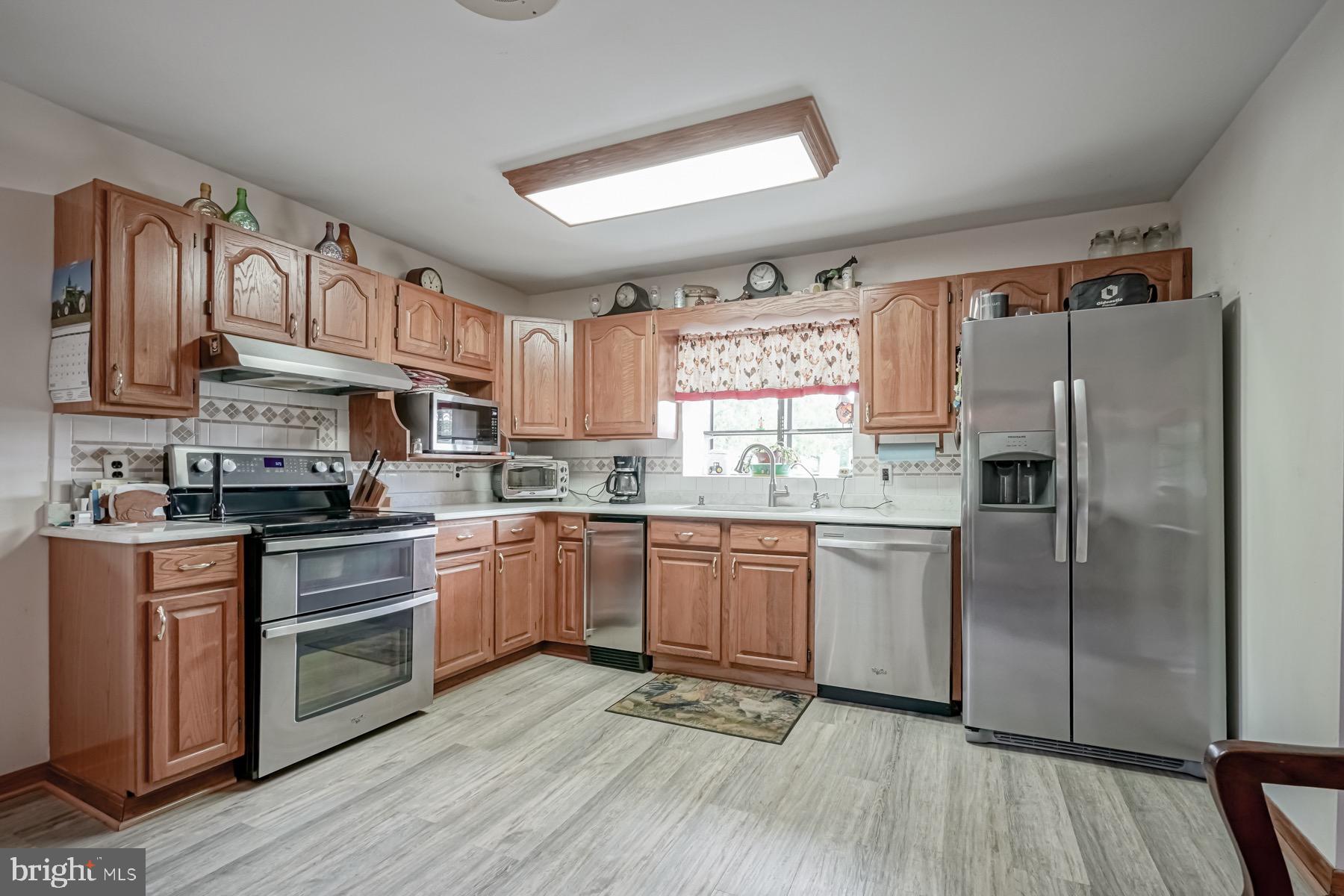 329 Lakedale Road Berlin, NJ 08009 - Photo 27 of 63 a kitchen with granite countertop stainless steel appliances a sink cabinets and a window