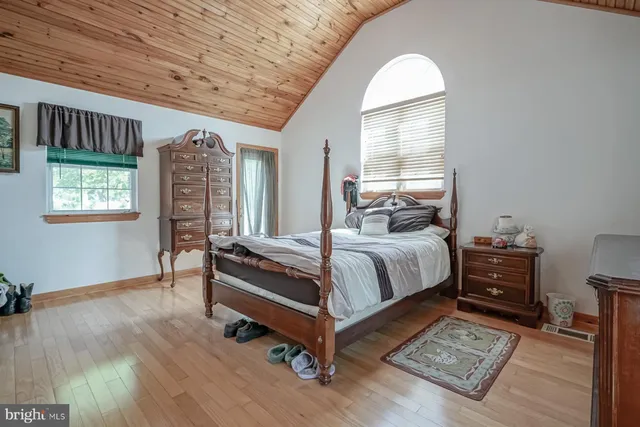 a bedroom with a bed and a dresser next to a window