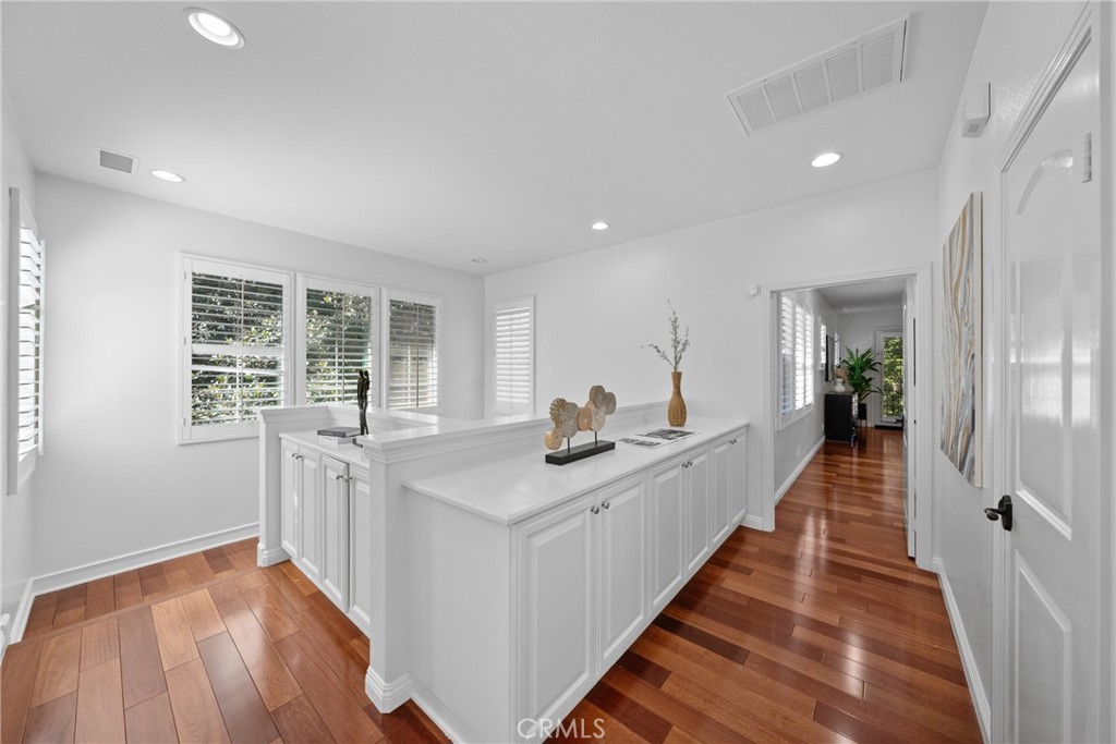 26 Twin Gables Irvine, CA 92620 - Photo 15 of 36 a view of a kitchen with kitchen island a sink wooden floor and a large window