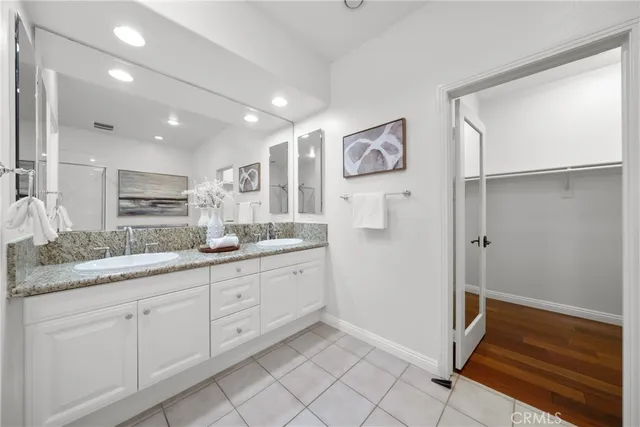 a spacious bathroom with a granite countertop sink and a mirror