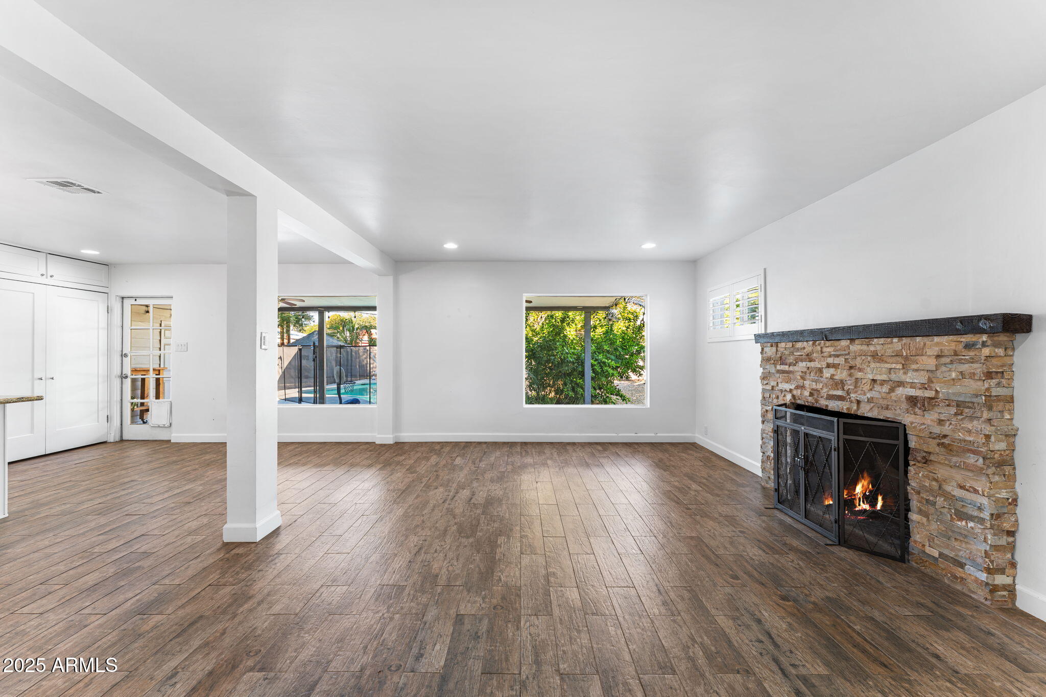 1334 West Sells Drive Phoenix, AZ 85013 - Photo 10 of 32 an empty room with wooden floor fireplace and windows