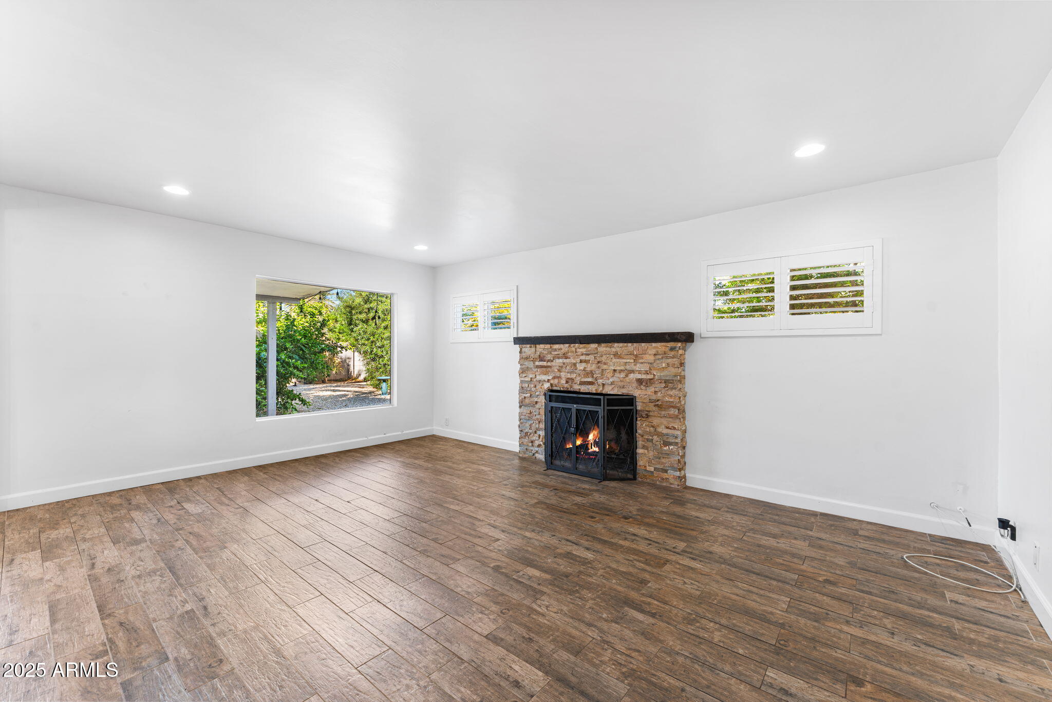 1334 West Sells Drive Phoenix, AZ 85013 - Photo 12 of 32 a view of an empty room with wooden floor and a window