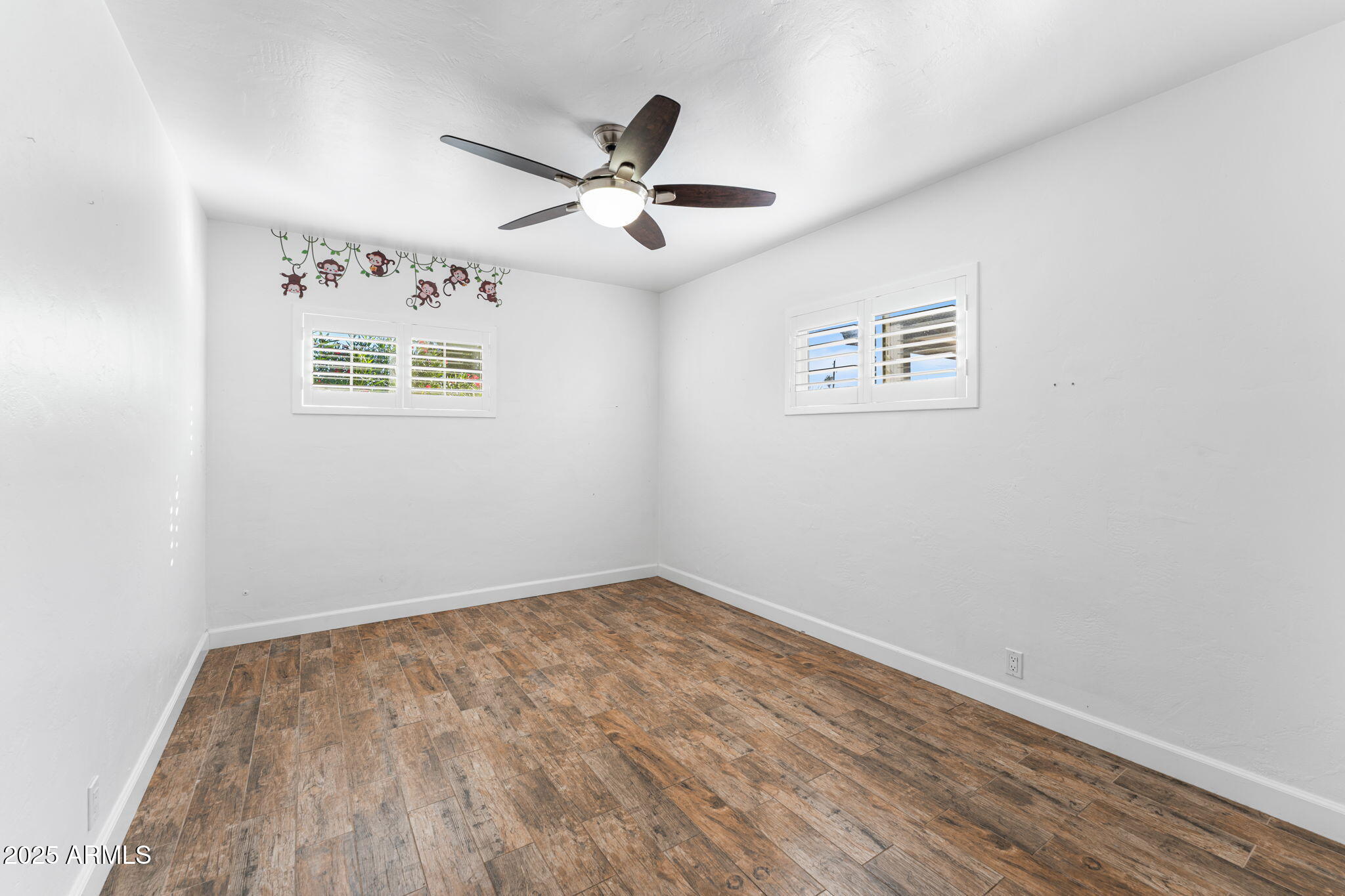 1334 West Sells Drive Phoenix, AZ 85013 - Photo 17 of 32 an empty room with wooden floor and ceiling fan