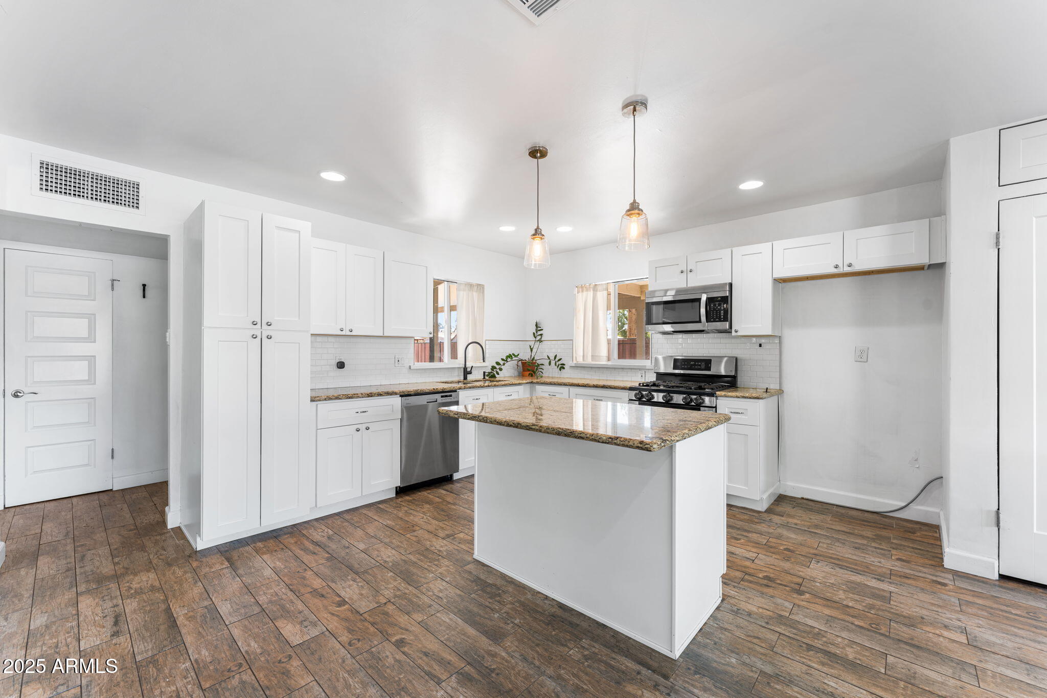 1334 West Sells Drive Phoenix, AZ 85013 - Photo 5 of 32 a kitchen with white cabinets and stainless steel appliances