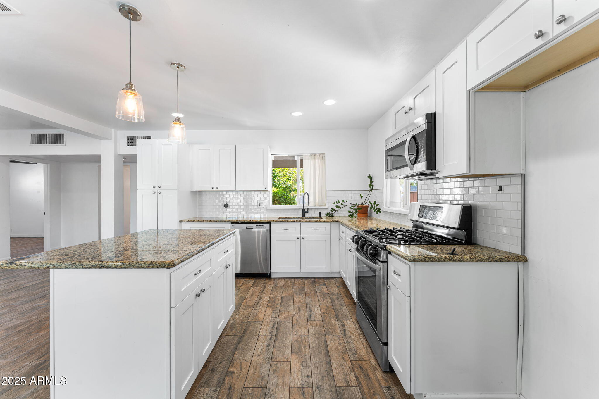 1334 West Sells Drive Phoenix, AZ 85013 - Photo 7 of 32 a kitchen with stainless steel appliances granite countertop sink stove and cabinets