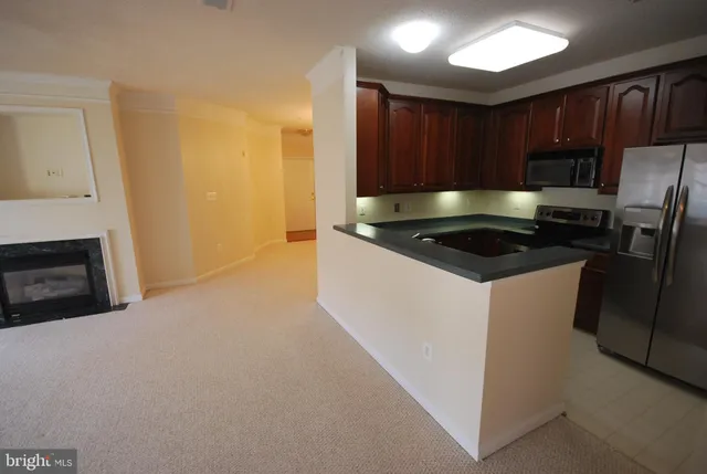 a kitchen with stainless steel appliances a stove a sink and a refrigerator with wooden floor