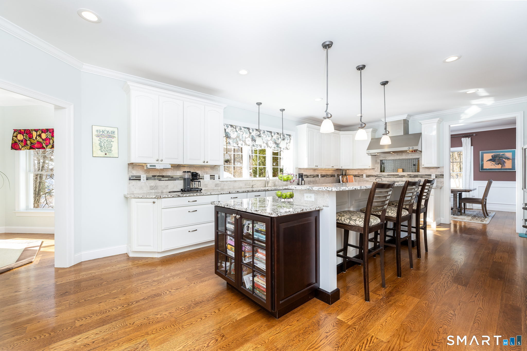 7 Hill Top Road Morris, CT 06763 - Photo 11 of 43 a kitchen with stainless steel appliances kitchen island granite countertop a stove top oven a sink a dining table and chairs with wooden floor