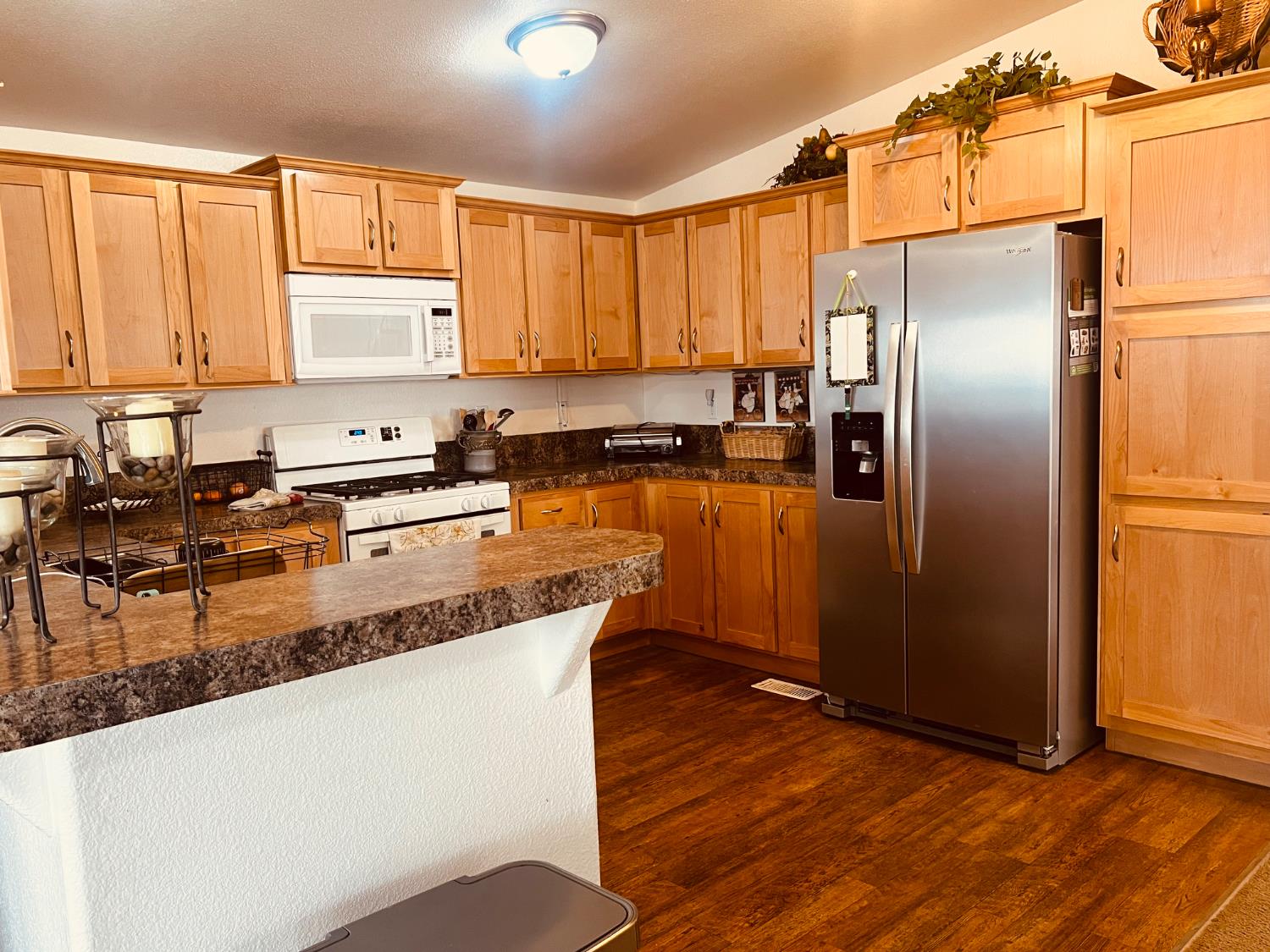 195 Schooner Lane Modesto, CA 95356 - Photo 7 of 24 a kitchen with granite countertop a refrigerator a sink a stove and wooden cabinets