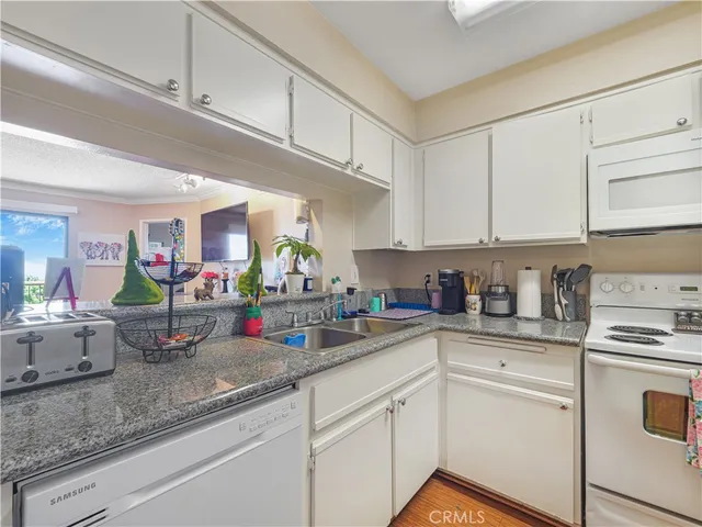 a kitchen with white cabinets and white appliances