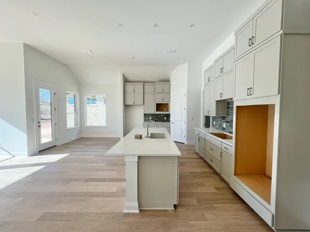 a large kitchen with kitchen island a sink stainless steel appliances and cabinets