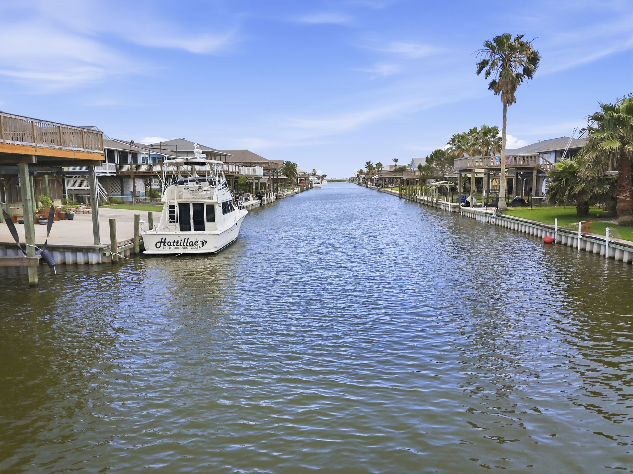 119 Sand Shoals Road Freeport, TX 77541 - Photo 3 of 34 Main canal view — deep, navigable canal with bulkheads on both sides, palm trees lining the water, and direct-out access for larger boats.