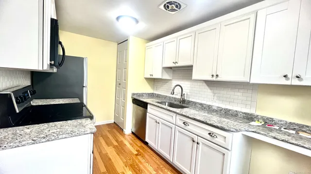 a kitchen with granite countertop a sink stainless steel appliances and cabinets