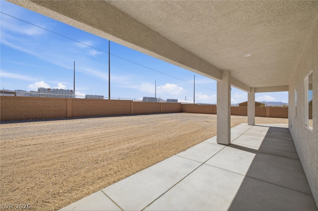 1061 Factory Road Pahrump, NV 89048 - Photo 33 of 41 A spacious, uncovered patio leads to a fenced yard, ready for personalized landscaping.