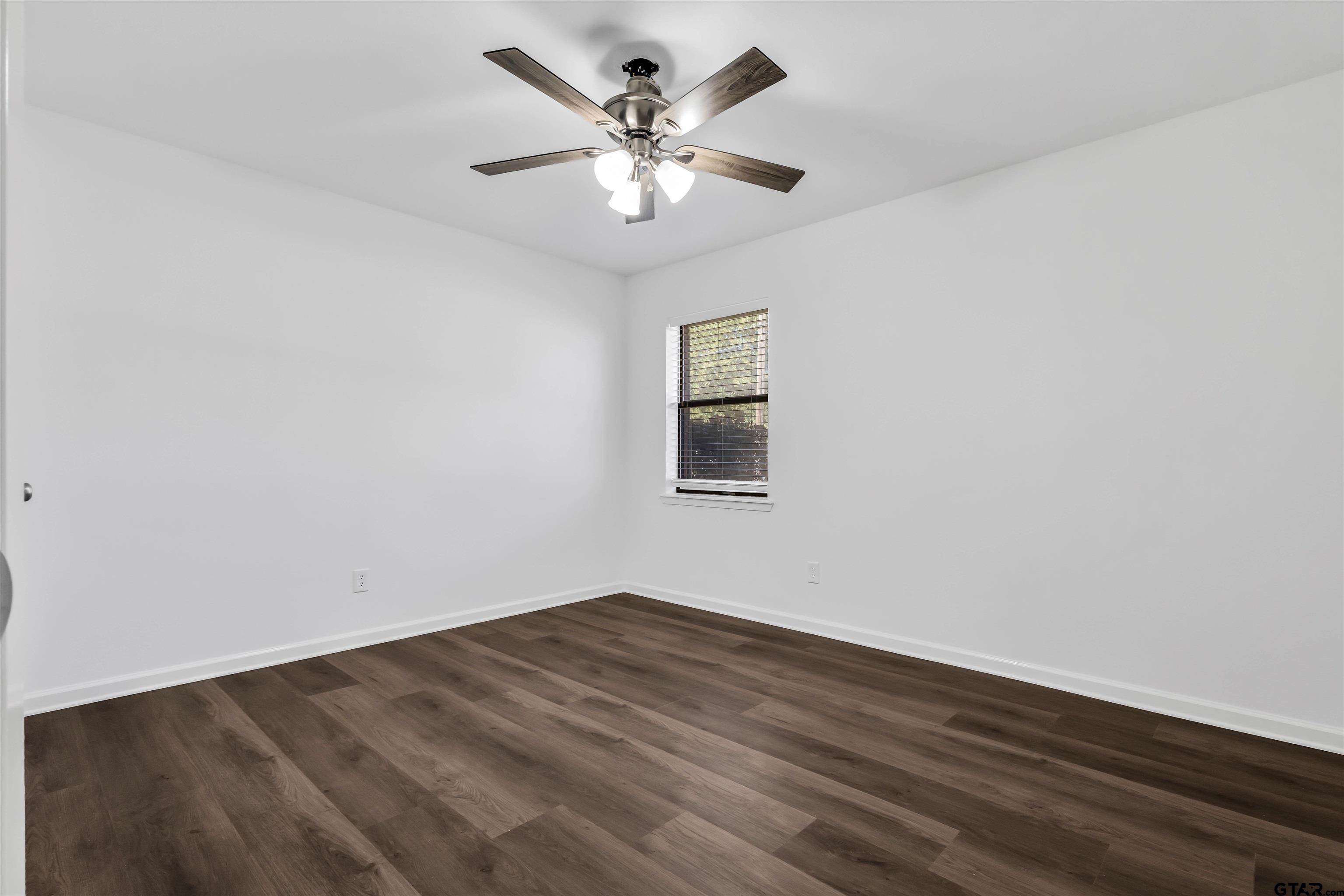 120 Laura Street Mineola, TX 75773 - Photo 21 of 27 an empty room with wooden floor and ceiling fan