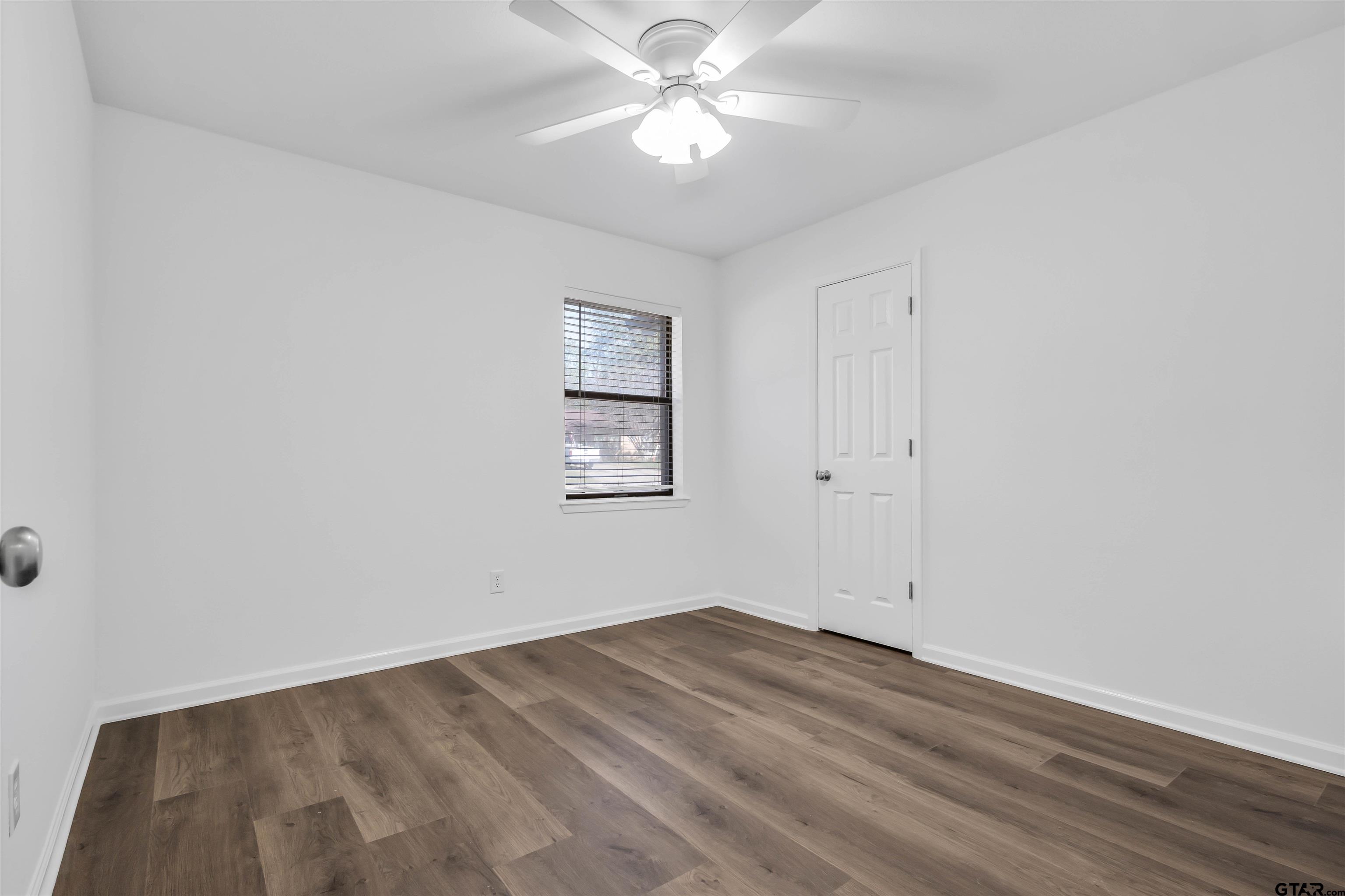 120 Laura Street Mineola, TX 75773 - Photo 23 of 27 wooden floor in an empty room with a window