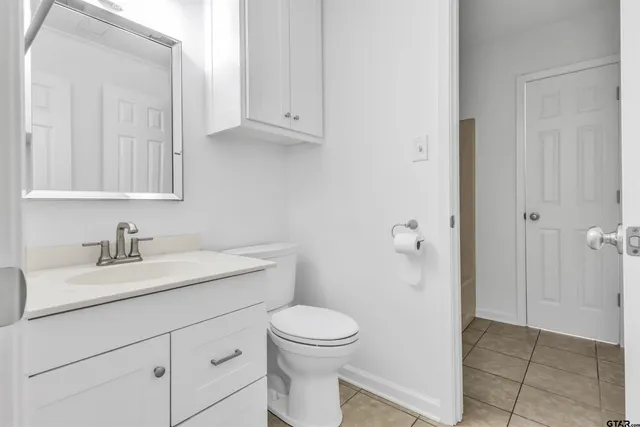 a bathroom with a granite countertop sink a toilet and a mirror