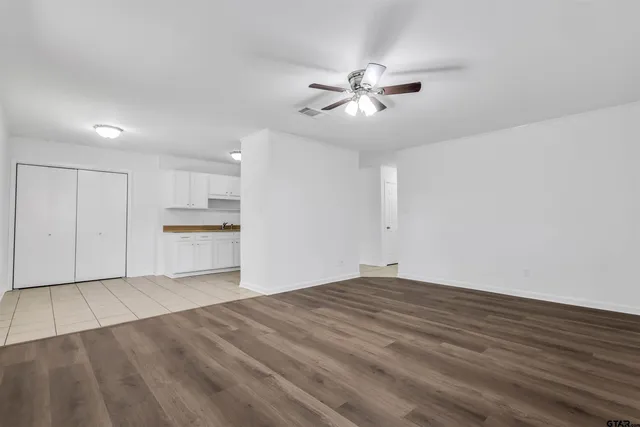 a view of empty room with wooden floor and window