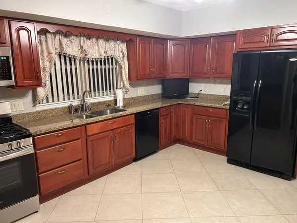 a kitchen with stainless steel appliances granite countertop a sink stove and cabinets