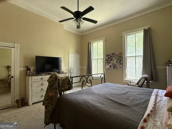 a bedroom with a bed and a flat screen tv