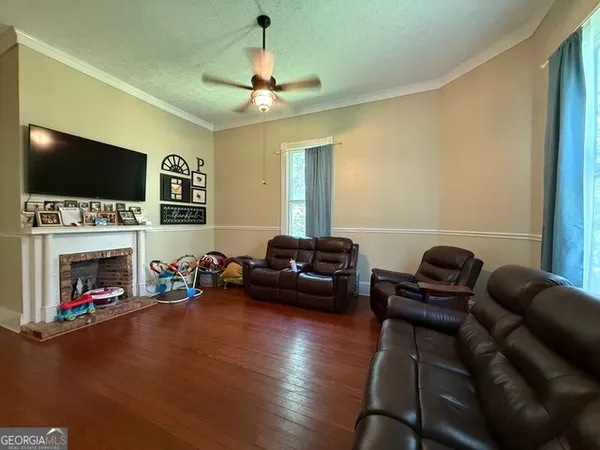 a living room with furniture a flat screen tv and a fireplace