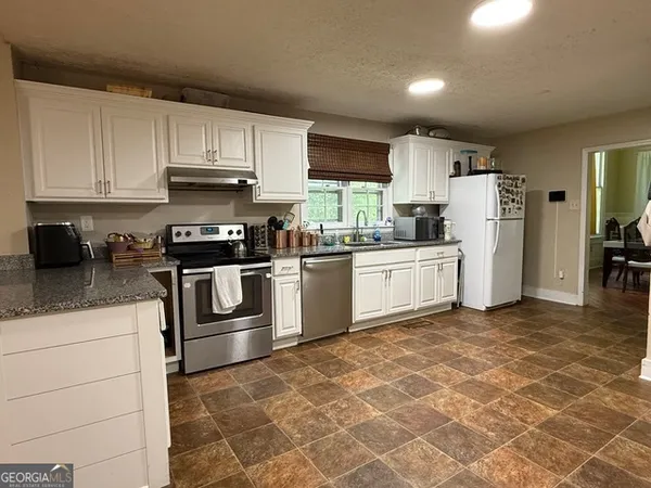 a kitchen with a sink a stove and cabinets