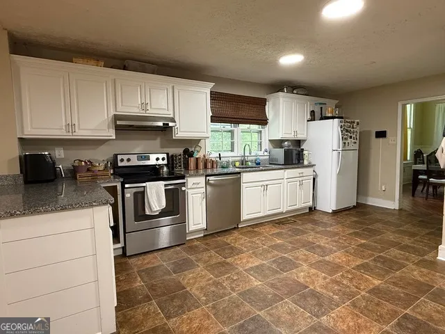 a kitchen with a sink a stove and cabinets