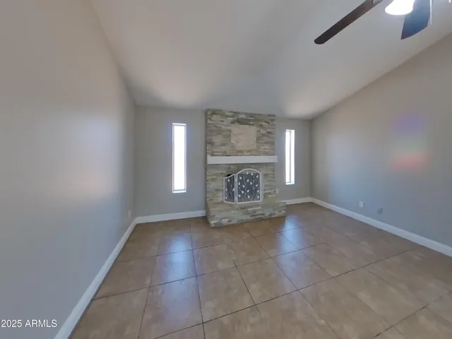 a view of an empty room with a fireplace and a window