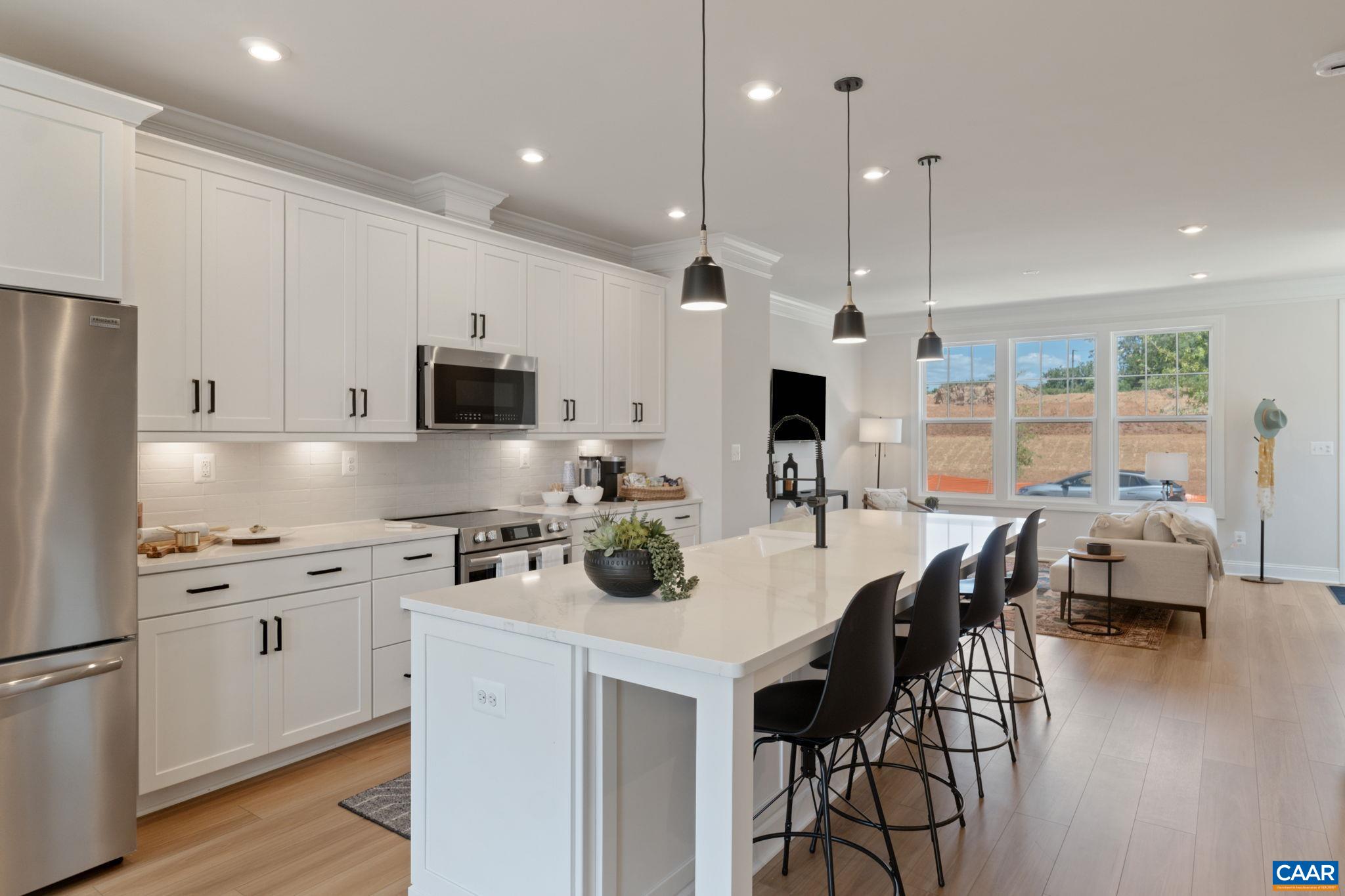 2215 Woodburn Road Charlottesville, VA 22901 - Photo 9 of 32 a kitchen with stainless steel appliances a stove a sink a microwave a refrigerator and white cabinets with wooden floor