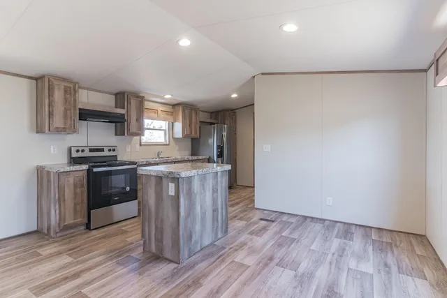 a kitchen with stainless steel appliances granite countertop a stove a sink and a refrigerator