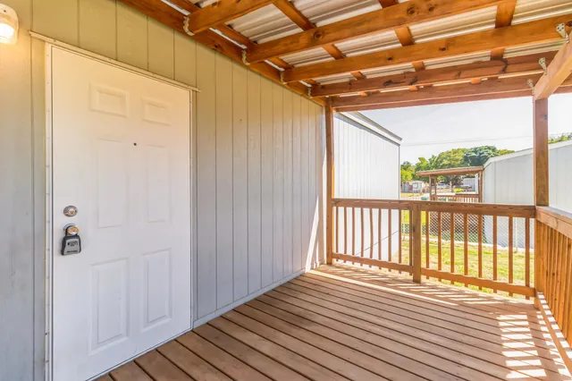 a backyard of a house with a barbeque and wooden fence
