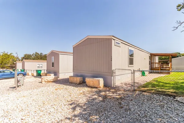 a view of a house with backyard and a tree
