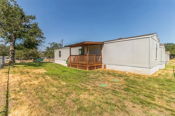 a kitchen with stainless steel appliances granite countertop a stove top oven a sink dishwasher and a refrigerator with wooden floor