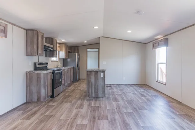 a kitchen with stainless steel appliances granite countertop a sink stove and wooden floor