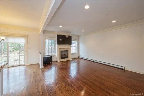 an empty room with wooden floor and fireplace