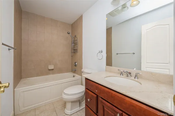 a bathroom with a granite countertop sink a toilet and shower