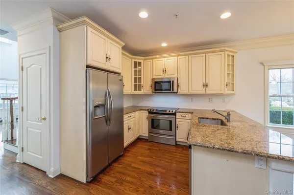 a kitchen with stainless steel appliances granite countertop a refrigerator sink and stove