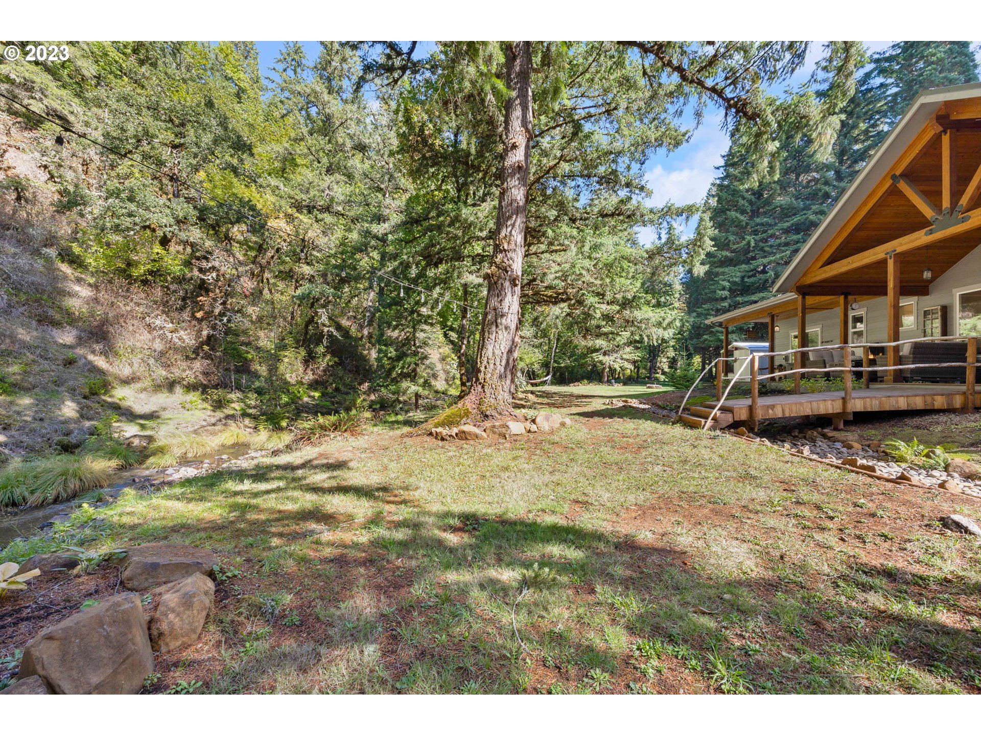 37693 Hills Creek Road Springfield, OR 97478 - Photo 38 of 48 a backyard of a house with large trees and wooden fence