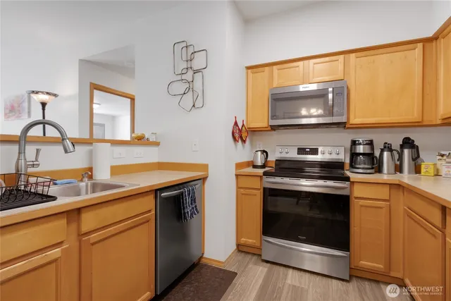 a kitchen with stainless steel appliances granite countertop a stove microwave and sink