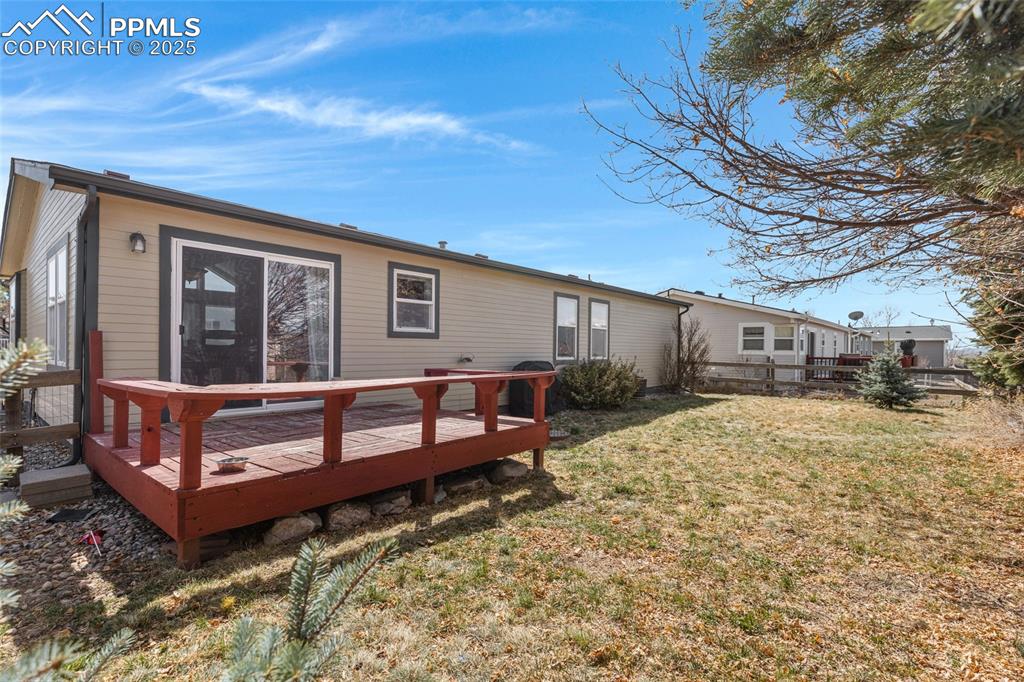 7659 Marmot Point Colorado Springs, CO 80922 - Photo 21 of 24 a view of a house with a large window and a yard