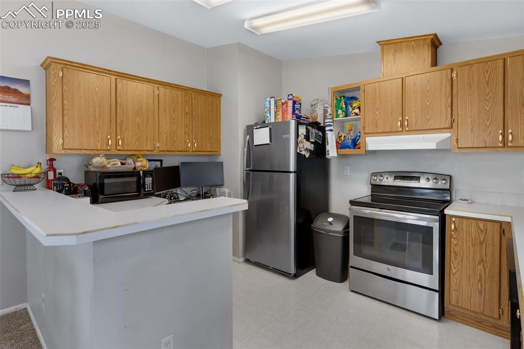 7659 Marmot Point Colorado Springs, CO 80922 - Photo 10 of 24 a kitchen with a refrigerator stove and a sink